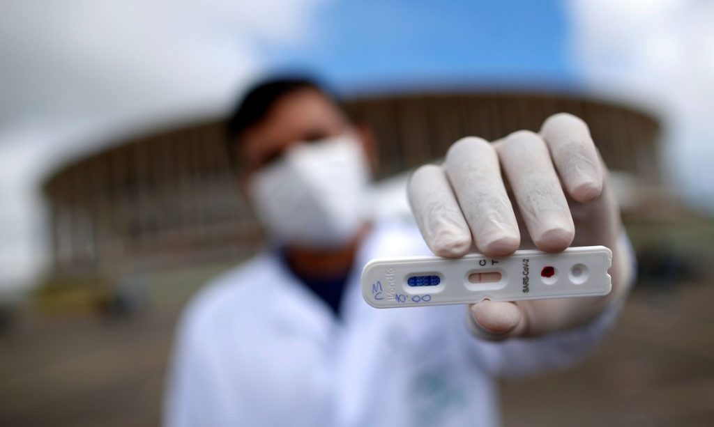 Um profissional médico mostra um teste negativo para o novo coronavírus em frente ao Estádio Mane Garrincha, em meio ao surto da doença por coronavírus (COVID-19), em Brasília, Brasil, 21 de abril de 